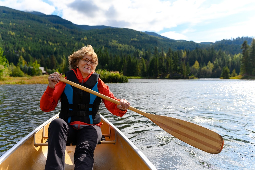 Retired woman paddling a canoe